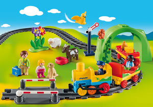  Playmobil 1.2.3 Mi primer Tren Viaja con Mi Primer Tren del 1.2.3 y descubre divertidos animales y flores preciosas. Los pasajeros pueden sentarse en el vagón de pasajeros mientras que el equipaje se transporta en el vagón de mercancías. Incluye túnel, paso a nivel y señal ferroviaria. También tiene 4 figuras de Playmobil 1.2.3, animales y mercancías.