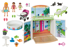 Cargar imagen en el visor de la galería,  Bungalow en la playa de Playmobil podrás recrear unas vacaciones de los más divertido. Incluye piscina pequeña, hamaca, mesa, maceta, lechuza, helado, cubo, barco y pez para jugar en el agua, dos gatitos. dos pares de chanclas y un carrito de bebé. Incluye tres figuras (adulto, niña y bebé). Incluye 67 piezas. 