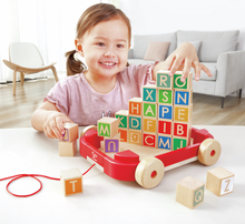 Carregar imagem no visualizador da galeria,  Arrastre Bloques Abecedario - Hape Los bloques tienen letras para que los más pequeños aprendan el alfabeto mientras apilan. Robusto carrito de arrastre con 26 bloques hechos de diferentes letras y colores. 