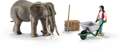 elefante con cuidadora. Incluye: elefante, figura de cuidadora, carretilla bala de paja y horquilla para manejar la paja. Las figuras de Schleich están pintadas a mano con enormes detalles